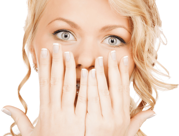 Frau mit blonden Haaren verdeckt ihre Zähne